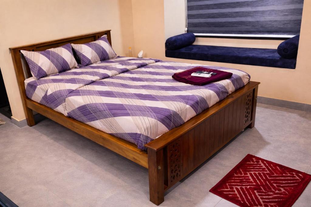 a bedroom with a bed with a wooden frame and a window at Crystal Homestay in Trivandrum