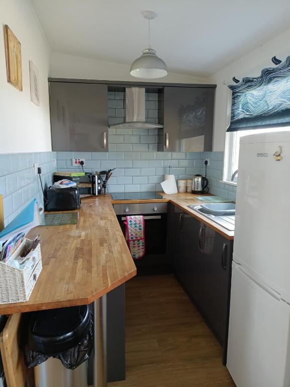 a kitchen with a wooden counter top and a refrigerator at 477 California Sands Chalets in Scratby