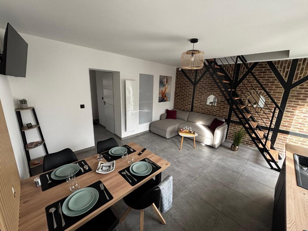 a living room with a dining table and a couch at L Orée des Thermes in Saint-Amand-les-Eaux
