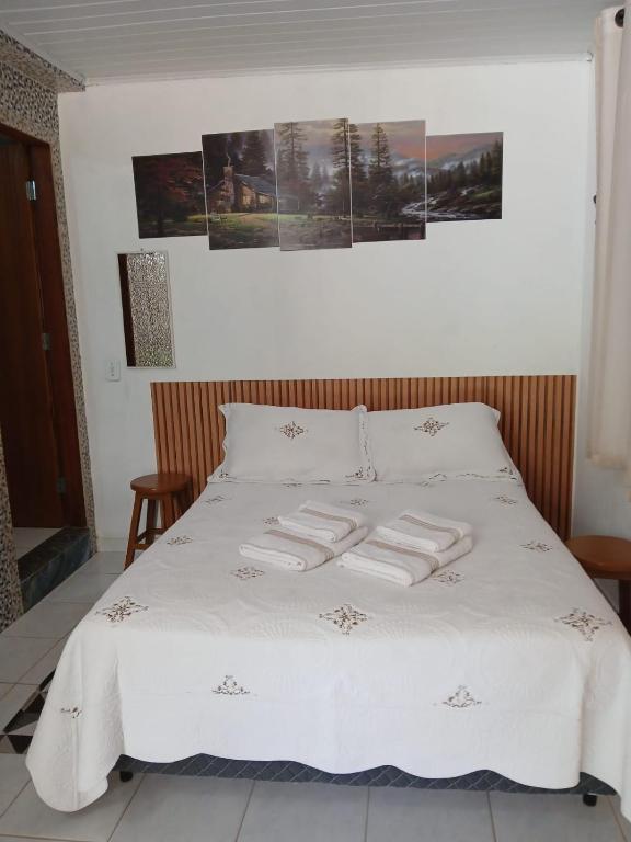 a white bed with two towels on top of it at Casa Nas Montanhas Capixabas in Domingos Martins
