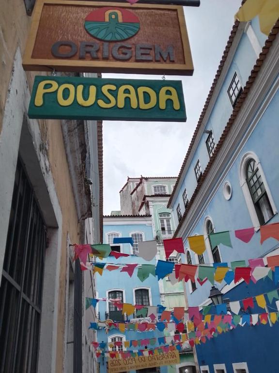 a sign for a restaurant on a building with flags at Origem Bahía in Salvador