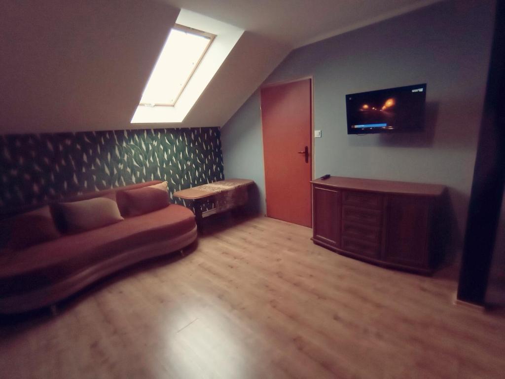 a living room with a couch and a tv at Chmurka in Bęczków