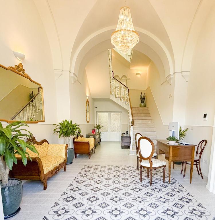 a living room with a staircase and a table and chairs at Palazzo Veneziani - Luxury Living in Monopoli in Monopoli