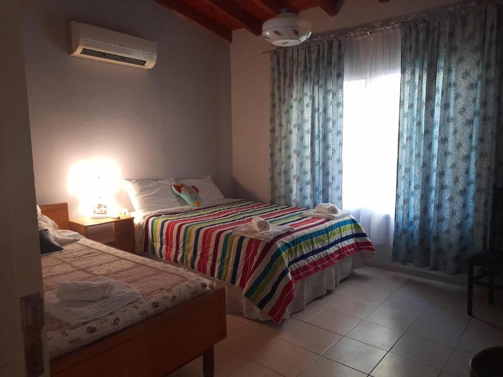 a bedroom with two beds and a window at Casita de Frasca in San José de Jáchal