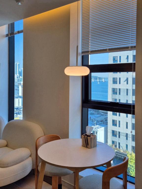 a living room with a table and chairs and a window at 로프트부산 loft busan in Samgong