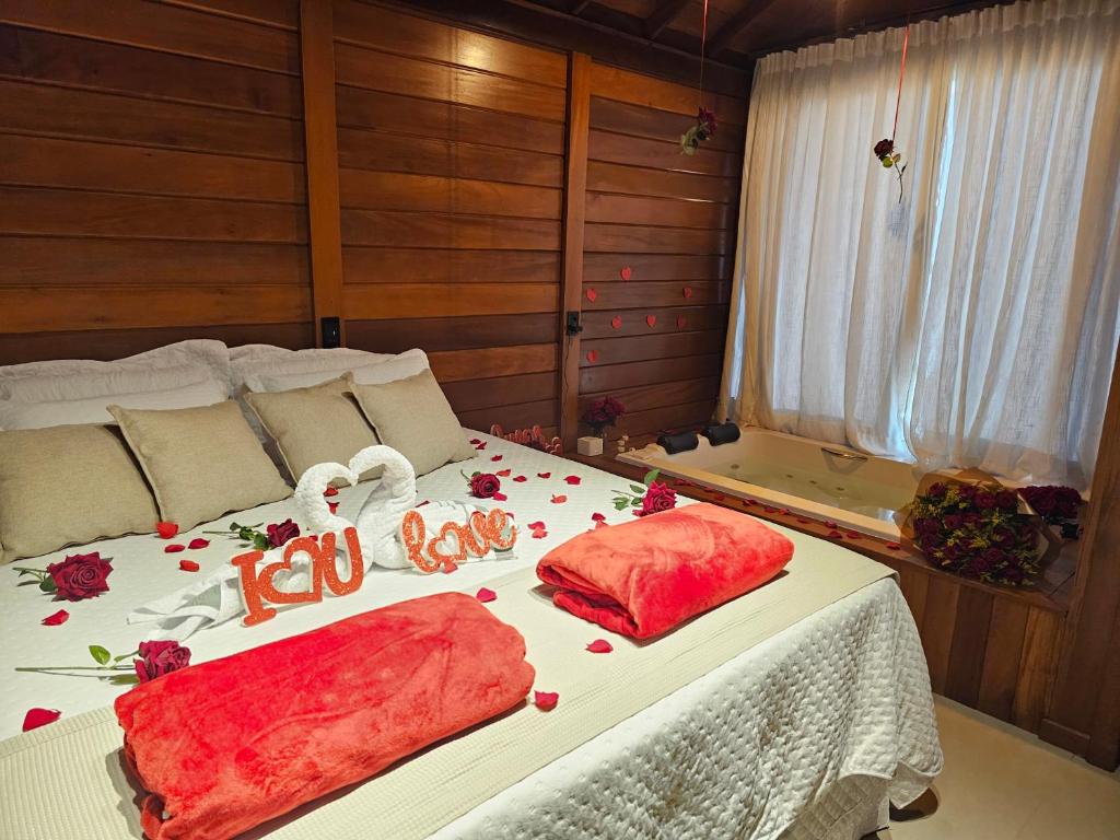a bedroom with a bed with red pillows on it at Chales Vista da Mata 01 in Santa Teresa
