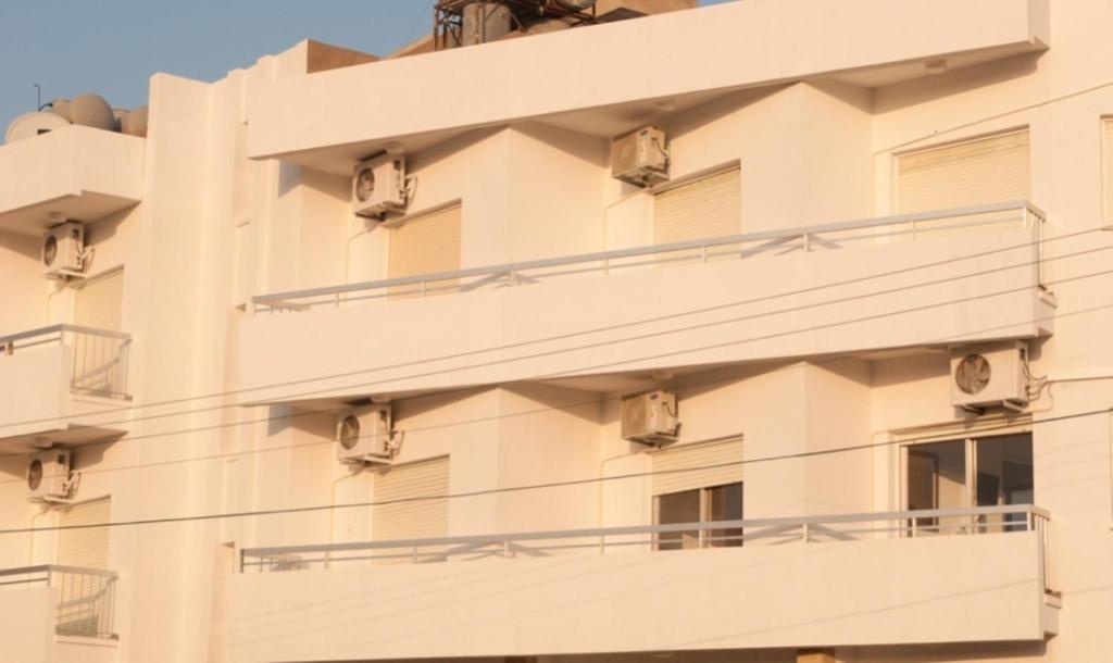 an apartment building with balconies on the side at St. George Rent Rooms in Larnaca