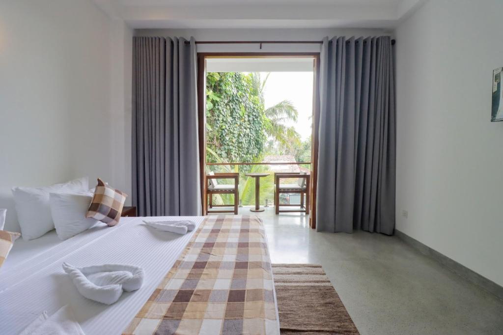 a bedroom with a large bed with a large window at Haru Ahangama in Ahangama