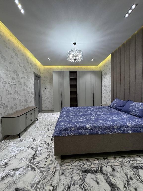 a bedroom with a large bed and a chandelier at White Guest House in Samarkand