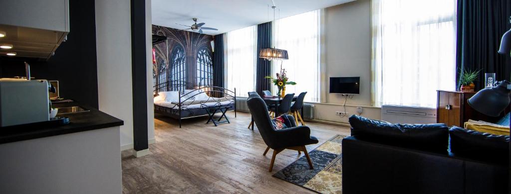 a living room with a couch and a table and chairs at ApartHotel Waepen van Middelburg in Middelburg