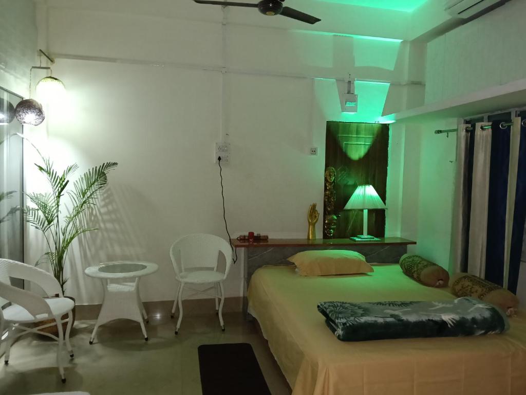 a bedroom with a bed and a table and chairs at Bijoy Villa in Guwahati