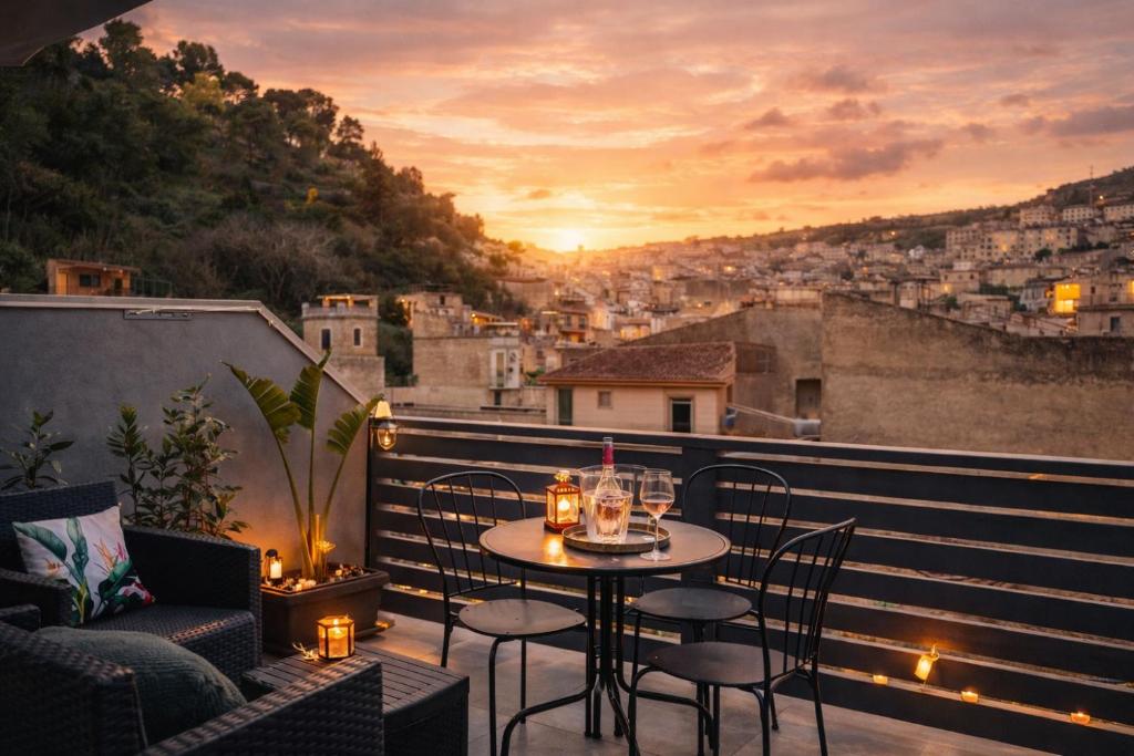 a patio with a table and chairs on a balcony at Tirella Home in Modica