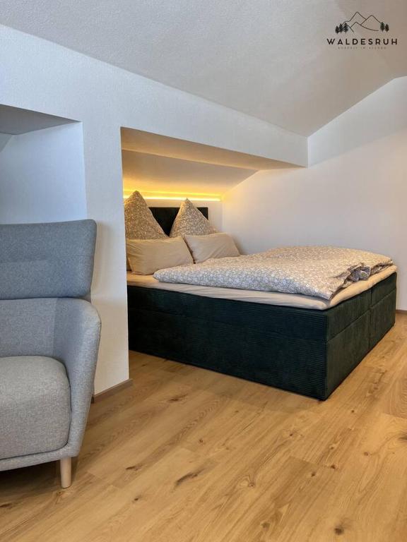 a bedroom with a bed and a couch at Waldesruh in Grünenbach