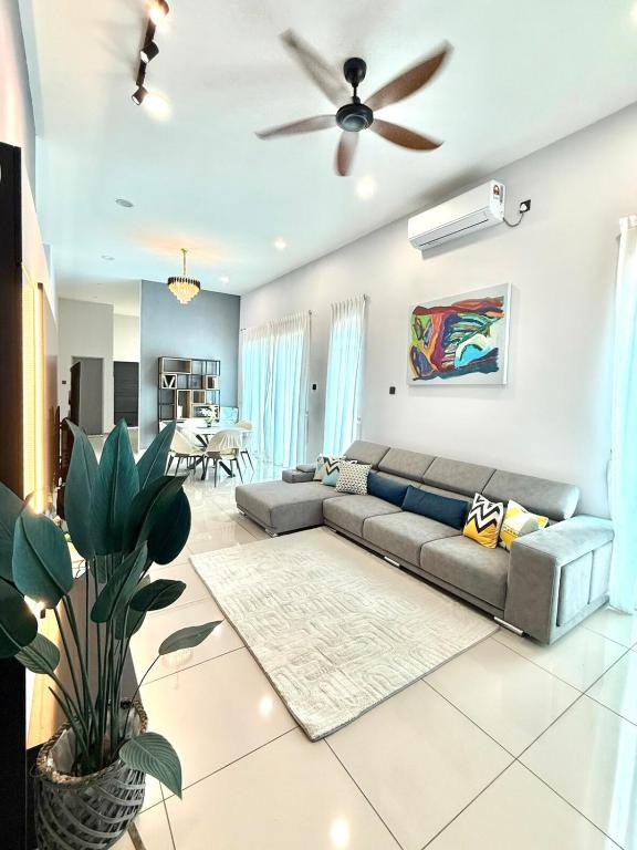 a living room with a couch and a ceiling fan at Jinta House Cherating in Kampong Baharu