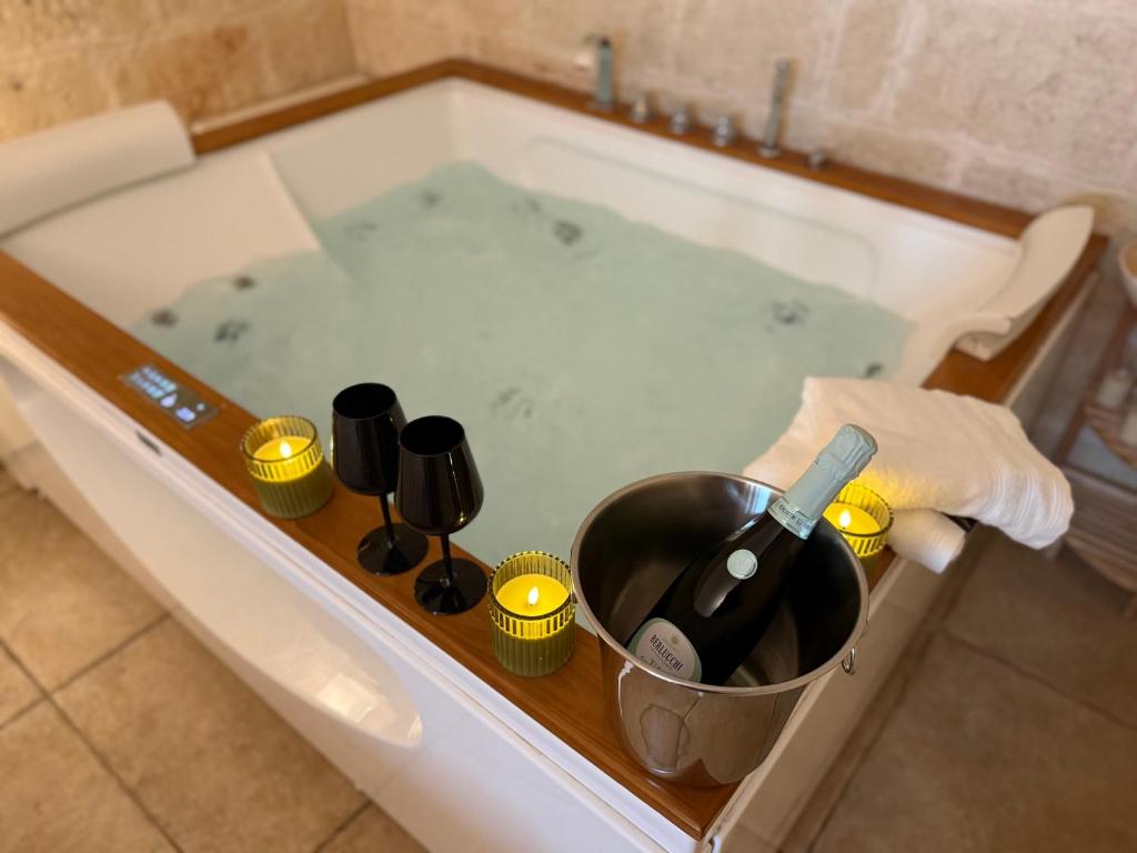 a bath tub with a bottle of wine and a bucket of champagne at La Suite in Centro con vasca idromassaggio - Relax & Spa in Bari