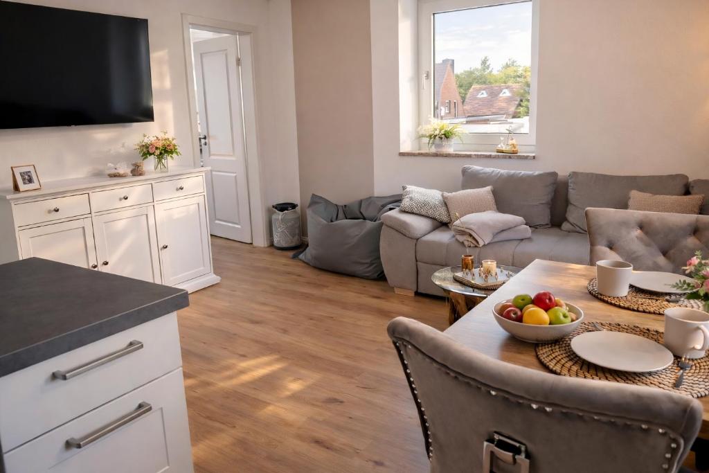 a living room with a table and a couch at Moderne Wohnung mit Privatpool in Büsum
