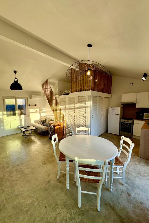 a living room with a table and chairs and a staircase at Grand studio avec terrasse in Saint-Marcel-lès-Valence