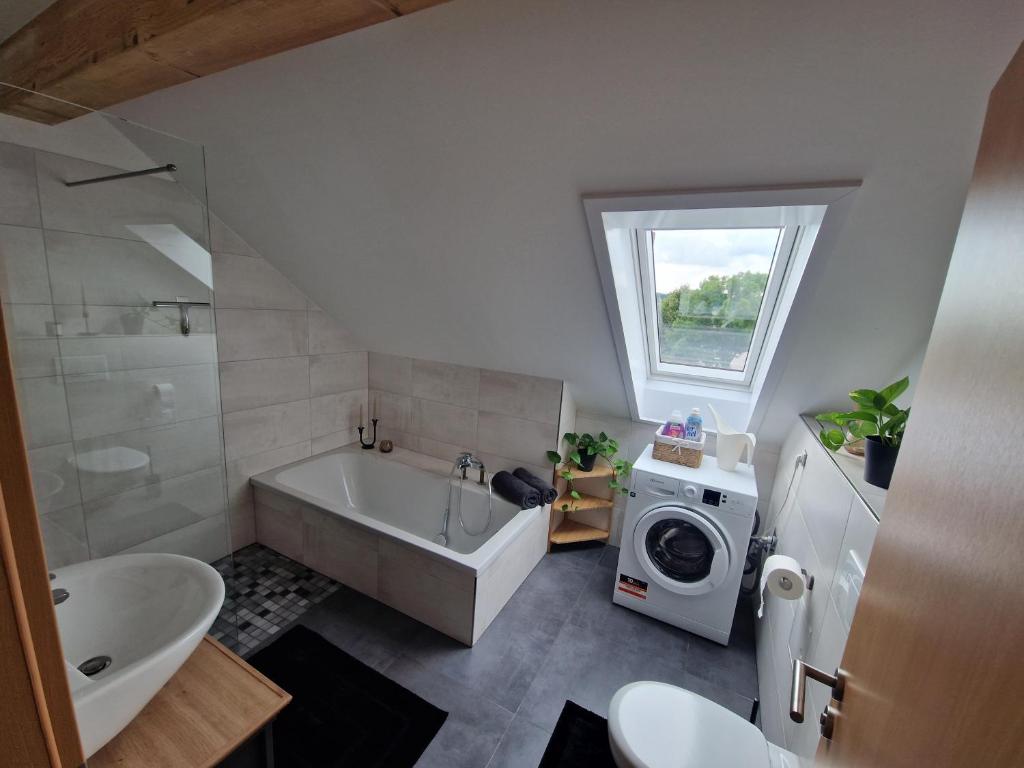 a bathroom with a tub and a washing machine at Moderne Ferienwohnung in Hainichen in Hainichen