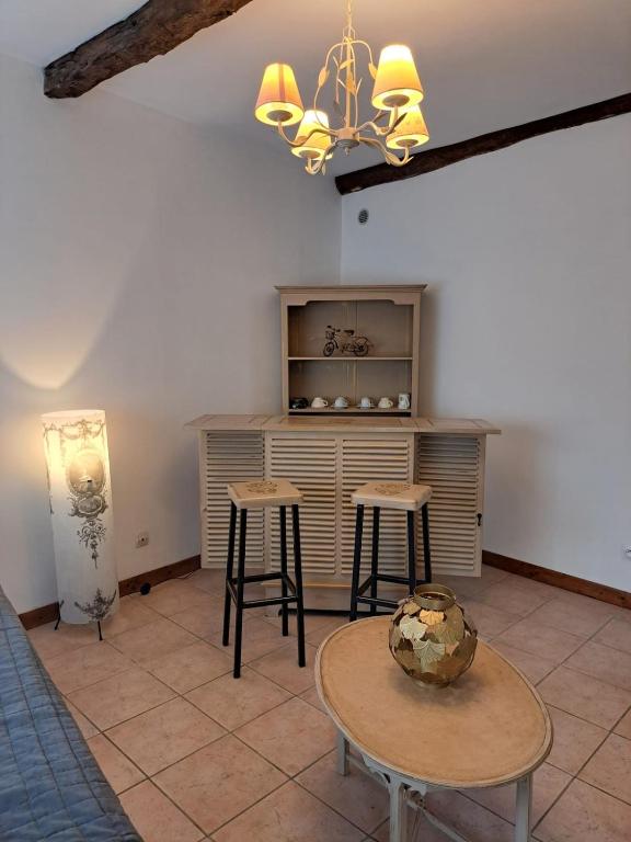 a room with two tables and a counter with stools at Logis du Bourg in Puy-lʼÉvêque