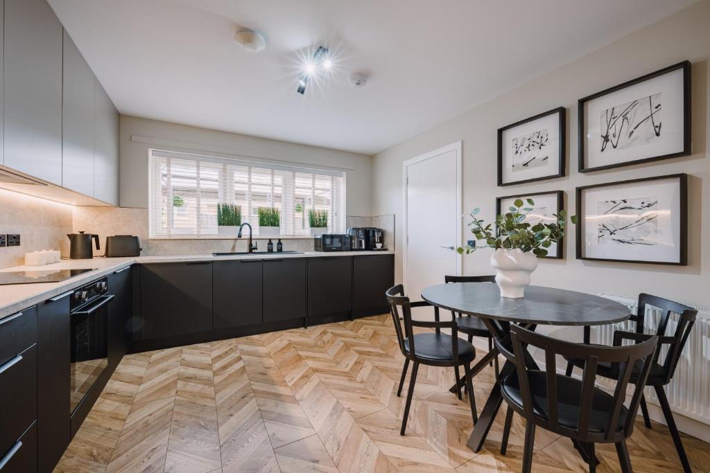 a kitchen with a table and chairs and a sink at JW Canmore ApartHouse in Glasgow
