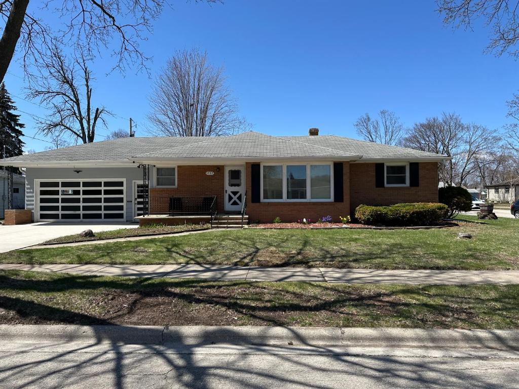 a brick house with a porch and a driveway at Blended Nest in Green Bay