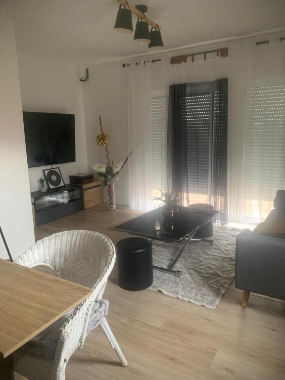 a living room with a table and a couch at Appartement douillet in Mirefleurs