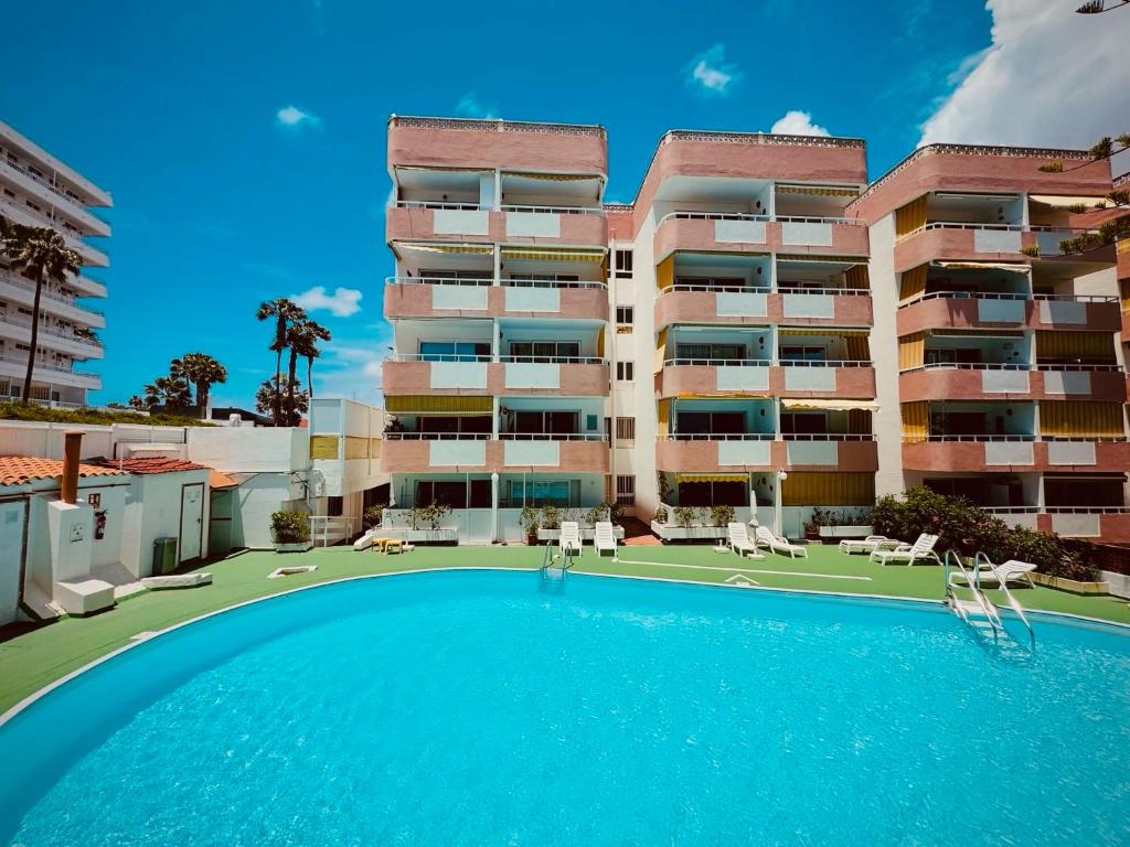 a swimming pool in front of a building at Valparaíso Apartments Flamingo in San Bartolomé