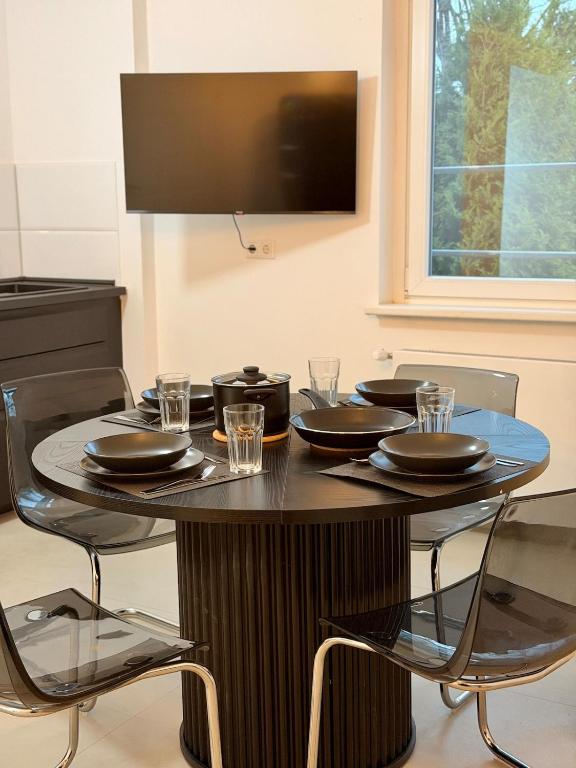 a table with black plates and glasses on it at Modern, bright apartment for individuals & groups in Remscheid