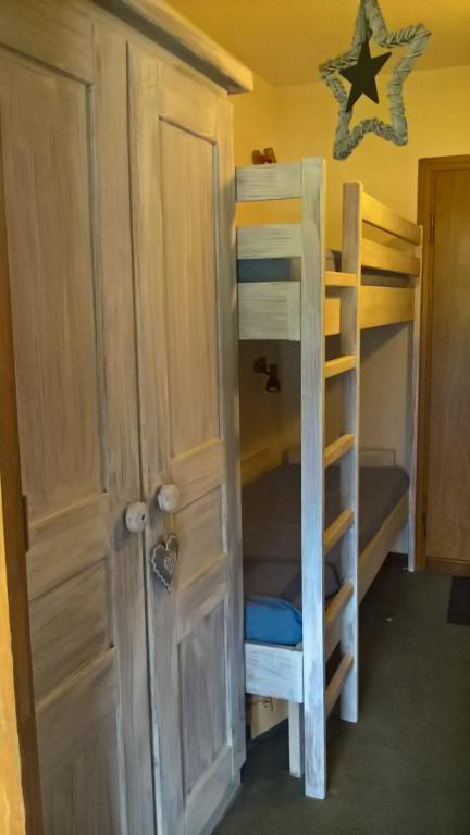 Zimmer mit Etagenbetten, einer Tür und einer Leiter in der Unterkunft Les Terrasses du Mont blanc in Le Praz de Lys