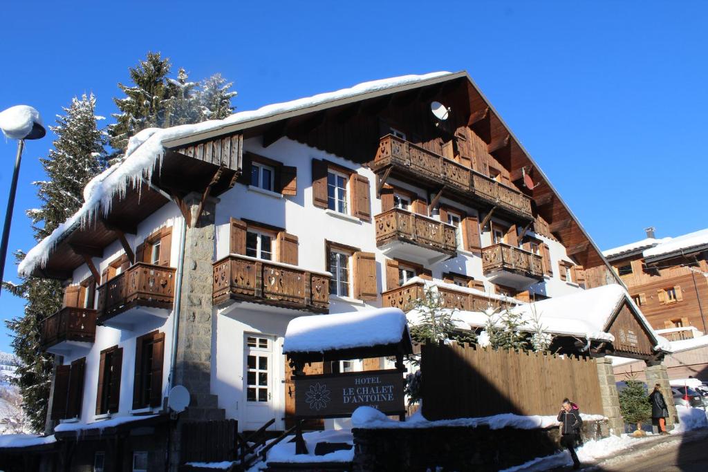 a large building with balconies on it in the snow at Le Chalet d'Antoine - Centre de Megève in Megève