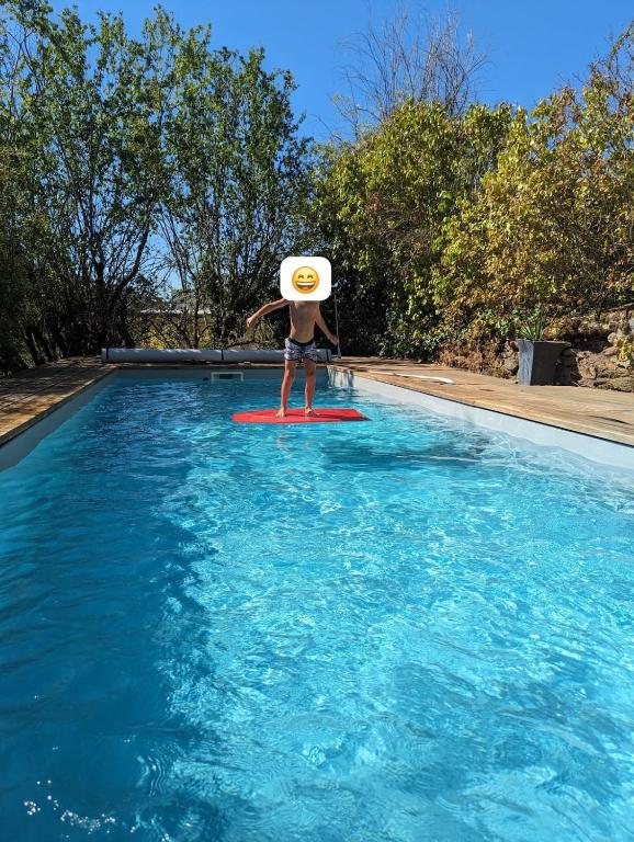 a person on a surfboard in a swimming pool at Le coin tranquille in Rodez