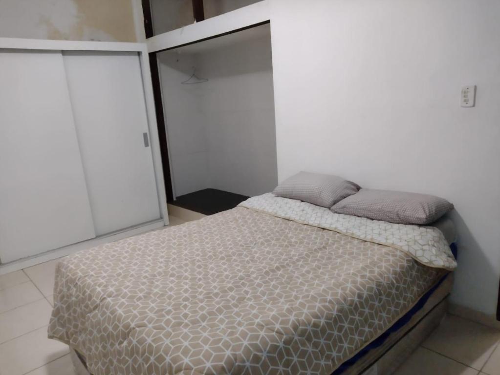 a bedroom with a bed with two pillows on it at Mar e sol in Itanhaém