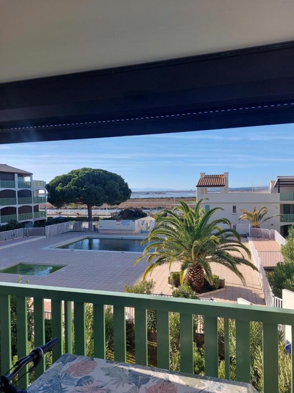 a balcony with a view of a pool at Le Grand Large in Gruissan