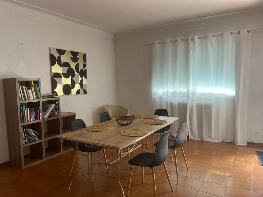 a dining room with a wooden table and chairs at La casa Marcel, maison de 110 m2 in Pia