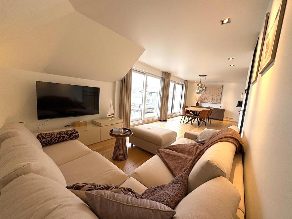 a living room with two couches and a flat screen tv at Maison Elouise in Middelkerke