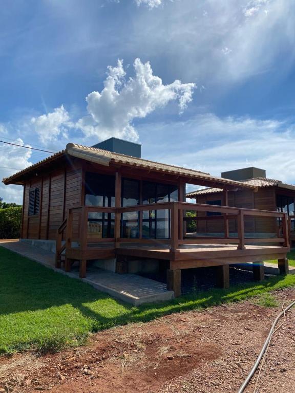a large wooden house with a large deck at Cerrado da Canastra Chalés in São Roque de Minas