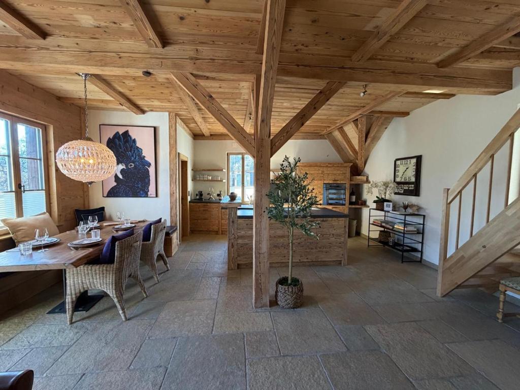 a dining room with a wooden ceiling and a table at Black Cockatoo Lodge close to Bern and Thun in Oberdiessbach