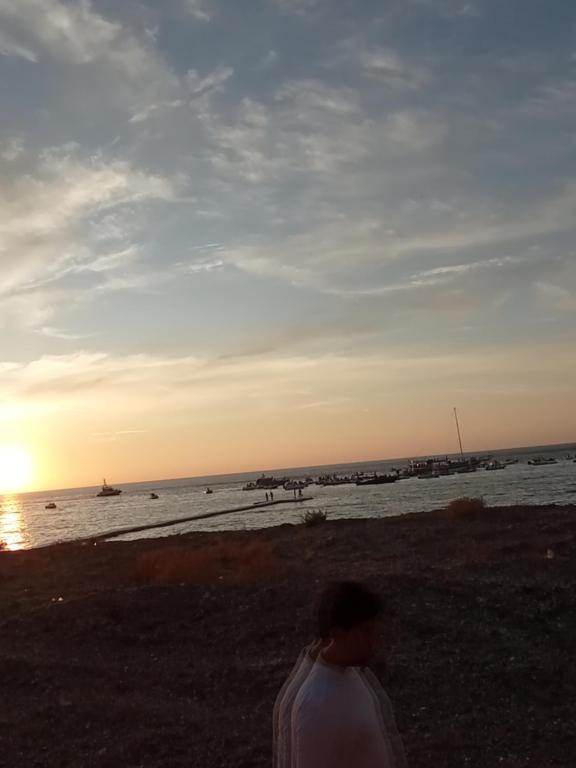a man standing on the beach with the ocean at Buonavacanza in Erice