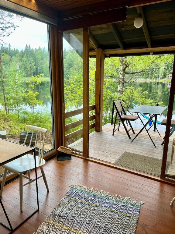 a screened in porch with a table and chairs at Nordic Experience Nuuksio Sauna in Nuuksio