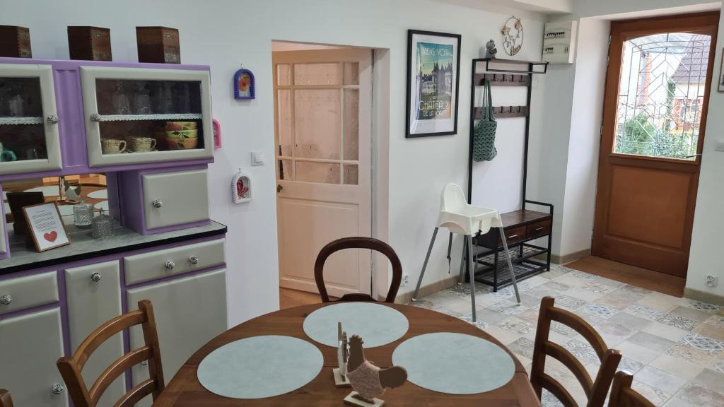 a kitchen with a table and chairs in a kitchen at Chez Mémère Paulette in Châtres-sur-Cher