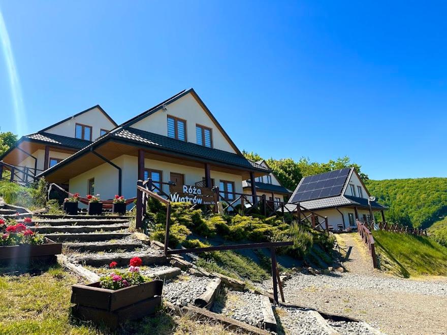 a house with stairs and flowers in front of it at Róża Wiatrów in Solina