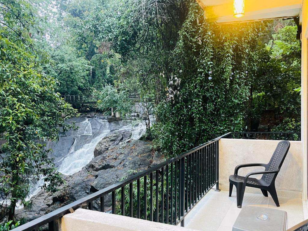 Ein Stuhl steht auf einem Balkon und blickt auf einen Fluss in der Unterkunft Ranmudu Hotel in Hanwella