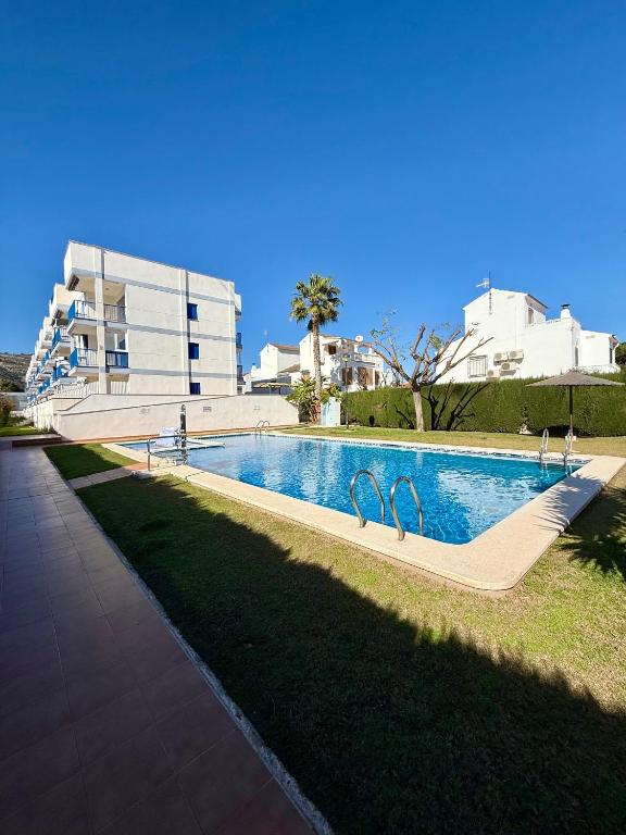 a swimming pool with two faucets in the grass at Apartamento Morro de Gos Ref067 in Oropesa del Mar