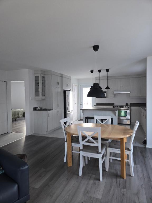 a kitchen and dining room with a table and chairs at Appartement de 2 chambre à la baie in Saguenay