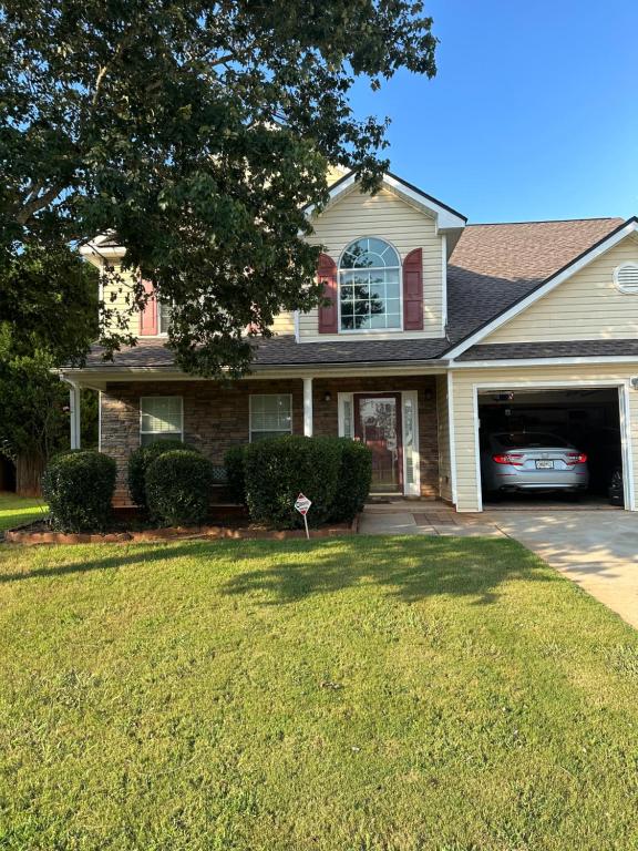 a house with a car parked in the driveway at Country house in Covington