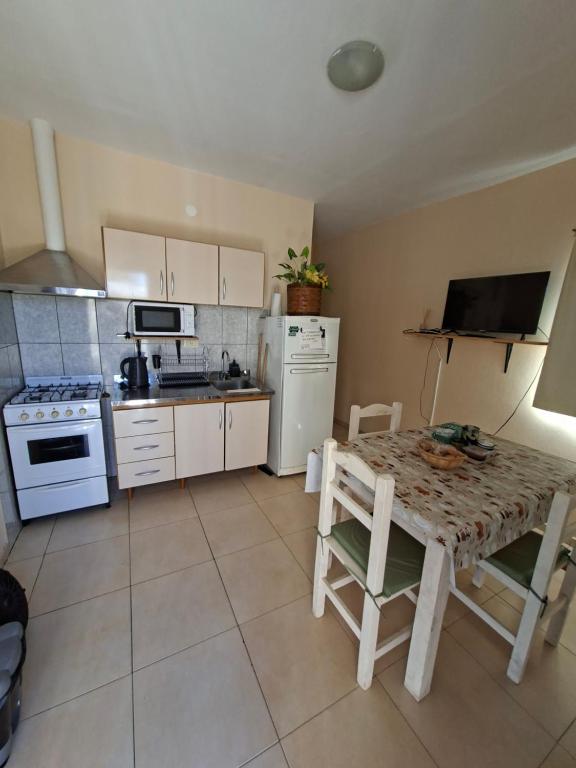 a kitchen with a table and a kitchen with white appliances at Departamentos Roxy in Viedma