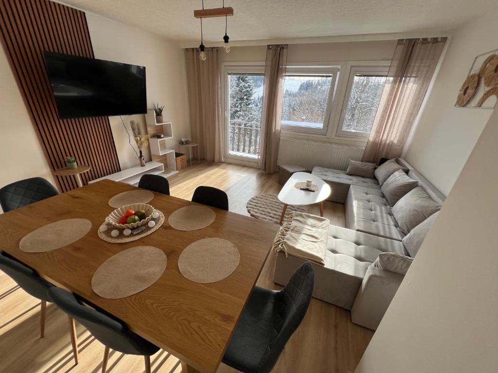 a living room with a table and a couch at Aldrovské Trio in Vítkovice