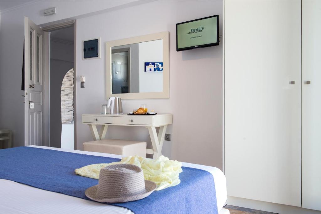 a bedroom with a bed with a hat on it at Kanale's Rooms & Suites in Naousa