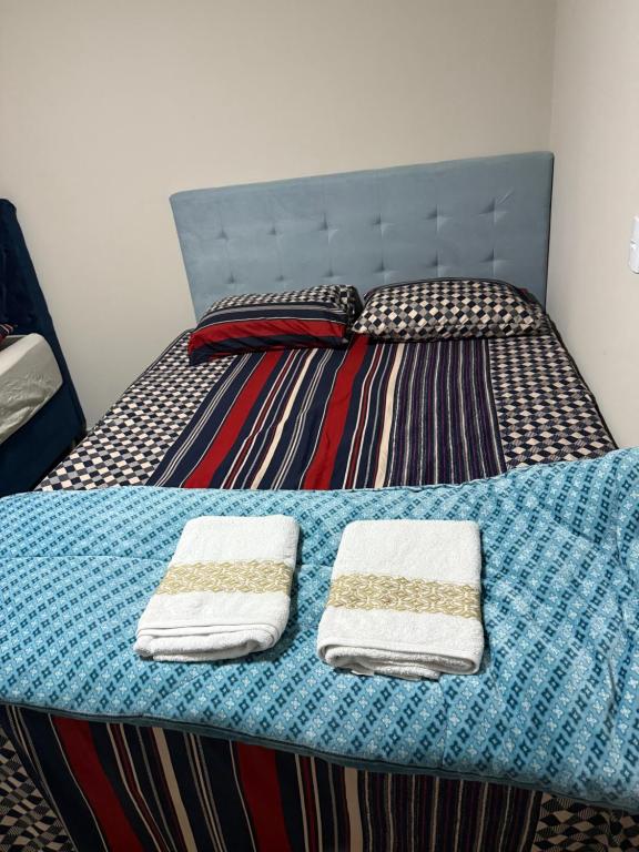 a bed with two towels on top of it at Chácara pontarolo in Guarapuava