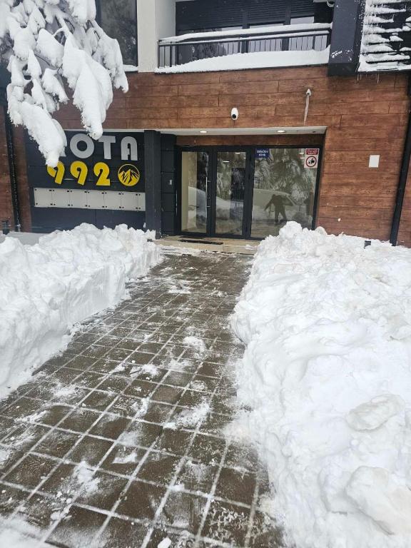 a pile of snow in front of a building at Apartman Mihajlo in Divčibare